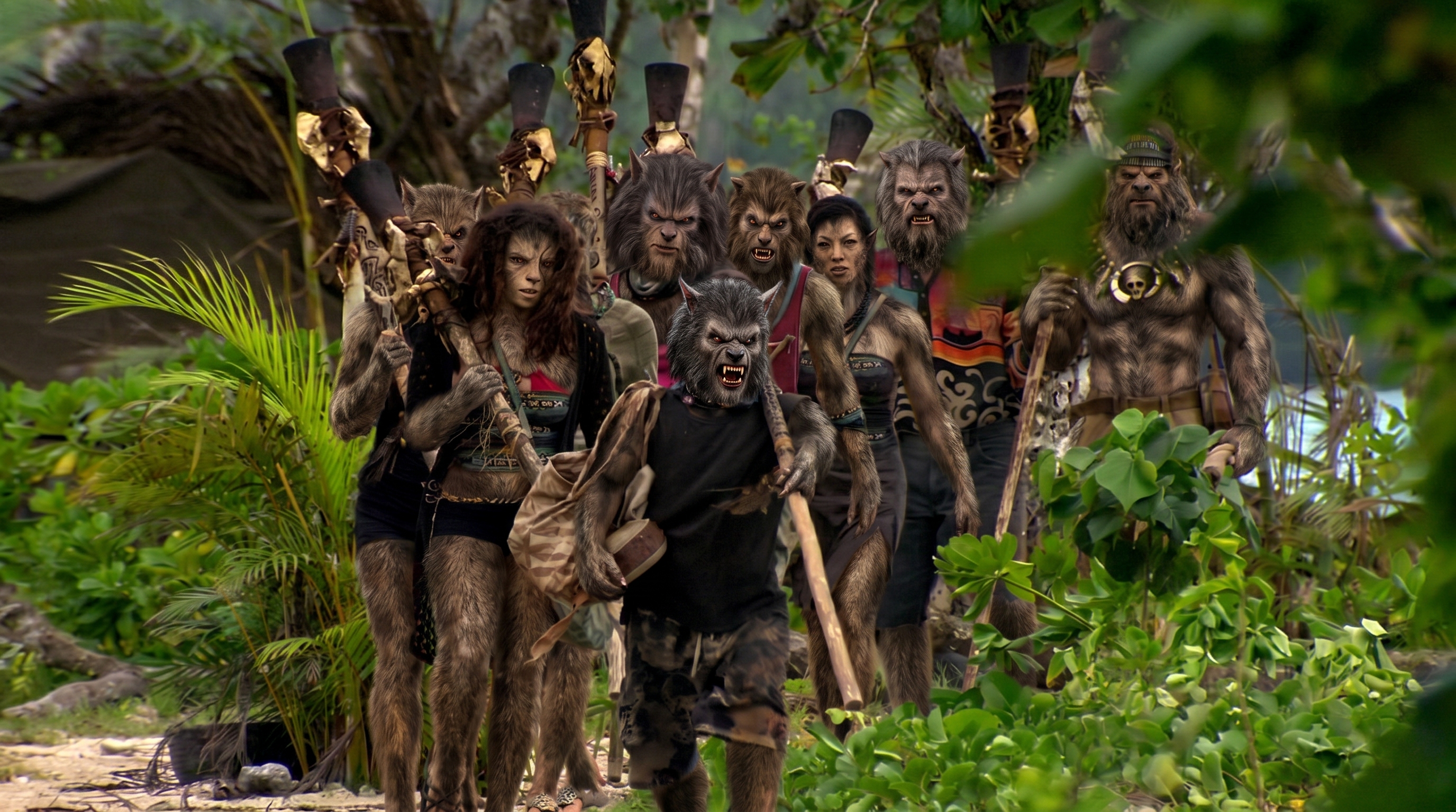 Tribe trekking through the jungle carrying torches and gear